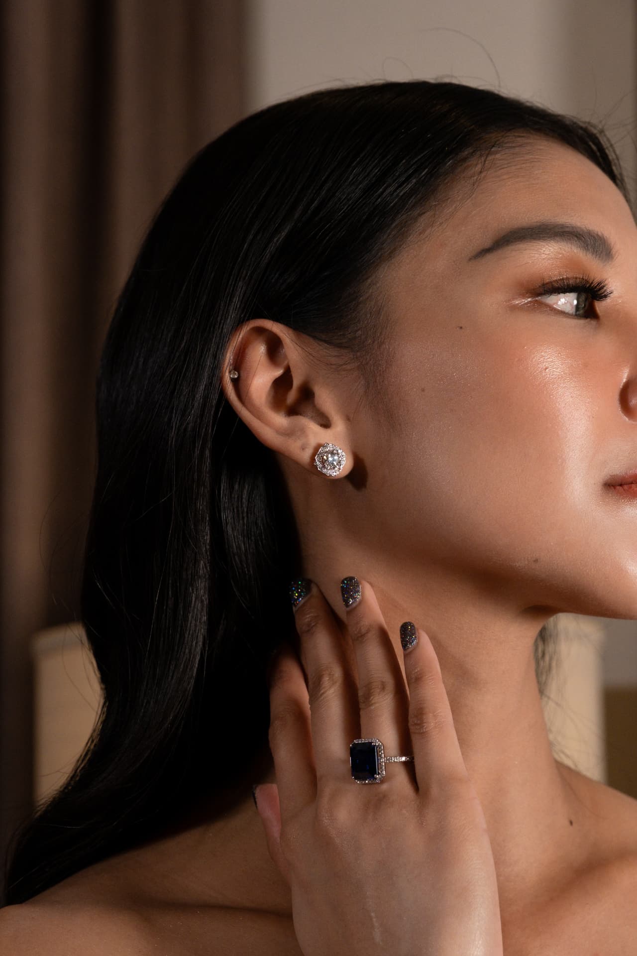 Sapphire ring and diamond earring detail portrait